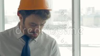 建筑大师、戴安全帽的商人在一个建筑工地内用平板电脑检查施工进度。 滑块